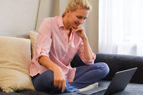 Mulher com laptop no sofá conversando online. treinador de comunicação web — Fotografia de Stock