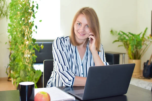 Mulher com laptop com telefone trabalhando, freelancer feliz em casa — Fotografia de Stock