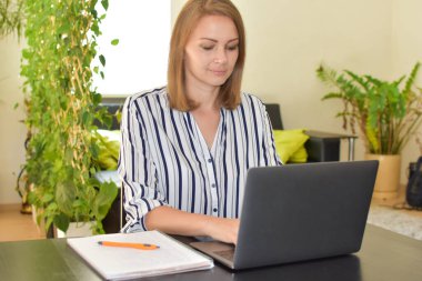 Genç kız, masadaki bilgisayarda çalışıyor..