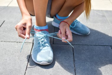 Açık hava ayakkabılarını bağlayan bir kız. Gençlerin spor hayatı
