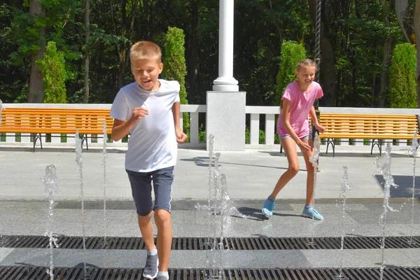 Веселые дети играют в уличном фонтане. детские игры в городской фонтан. — стоковое фото