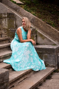 Taş üstünde güzel elbiseler giyen kadın model..