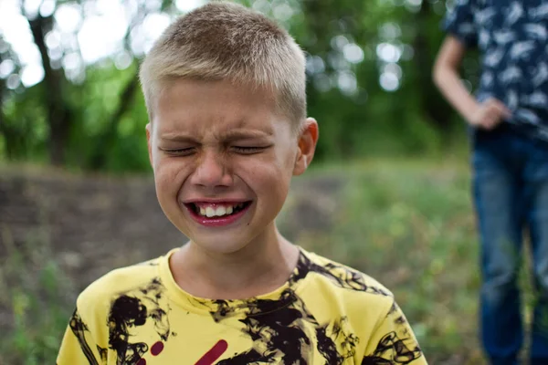 O rapaz está a chorar ao ar livre. A criança adolescente está chorando. Forte ressentimento da criança. — Fotografia de Stock