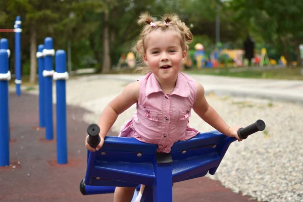 Bebé riendo niña en el patio de recreo. Joven deportista lindo. — Foto de Stock