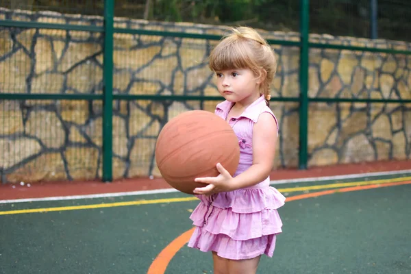 Baby laughing little girl on the playground. Young cute sportswoman. — Stock Photo, Image