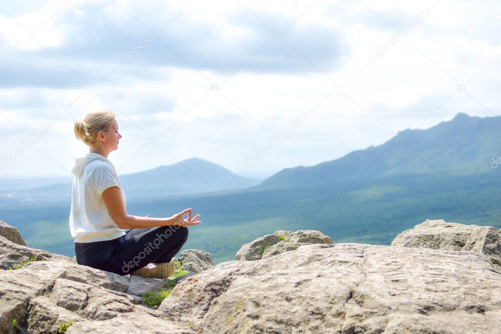 young woman sits relaxed in nature. outdoor recreation. Meditation in nature.