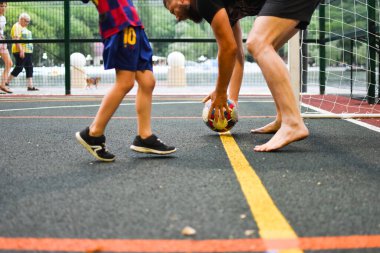 Spor sahasında futbol oynamak. aktif çocuk futbol topunu tekmeliyor.