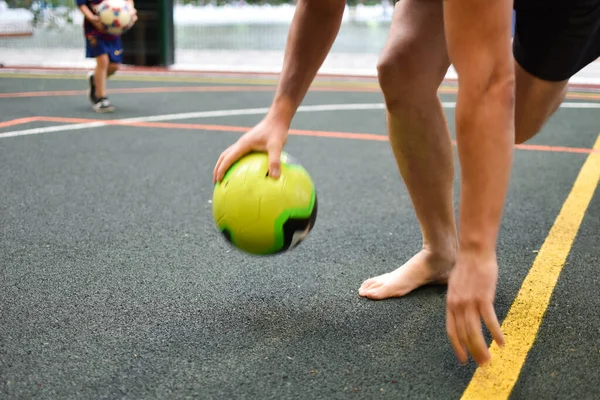 野球場でサッカーをしています。現役の子供がサッカーボールを蹴り. — ストック写真