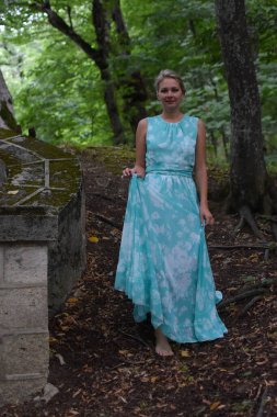 Yazın şehir parkında elbise giymiş güzel bir genç kadın..