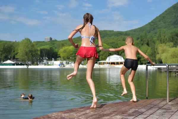 Zwei Kinder, Mädchen und Jungen, die gemeinsam Spaß in der Natur haben. Bruder und Schwester glücklich freundschaftliches Spiel zusammen. — Stockfoto