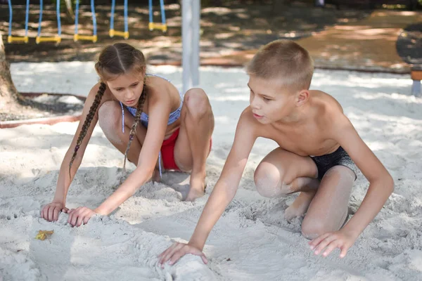 Dua anak, laki-laki dan perempuan bersenang-senang di alam. Kakak dan adik senang bermain bersama-sama. — Stok Foto