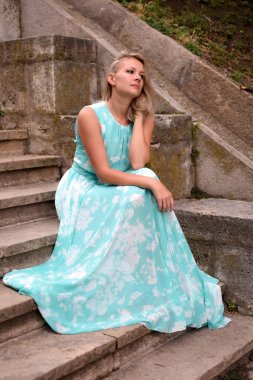 Genç bir kadın doğadaki yaz parkında dinleniyor. Dalgın sarışın açık hava kızı