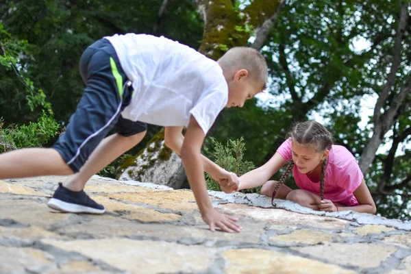 Pojke och flicka leker på berget. barn turister resenärer klättra berg. — Stockfoto