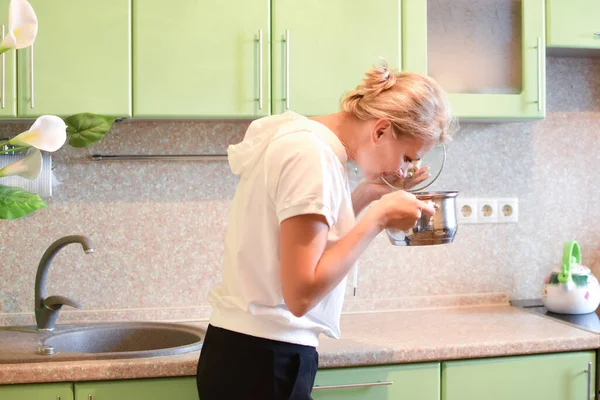 Femme cuisine dans la cuisine confortable à la maison. femme au foyer prépare le dîner dans une casserole — Photo