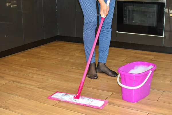 Dona de casa lava pisos em casa. trabalho de limpeza doméstica de rotina — Fotografia de Stock