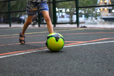Küçük çocuk parkta futbol oynuyor. spor etkin çocuk