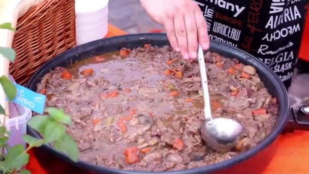 Mâncare stradală, fast food, vânzător vinde gulaș delicios de carne într-o cafenea stradală — Videoclip de stoc