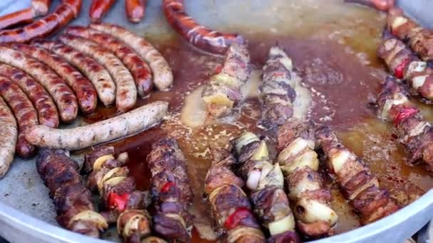 Festival of street food. Delicious fresh sausages and kebab fried on a large frying pan at an outdoor cafe. — Stock Video