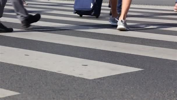 Veel mensen steken de straat over op een kruispunt. voeten close-up — Stockvideo