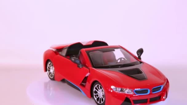 Červené sportovní auto scale model auto otáčení na bílém pozadí. — Stock video