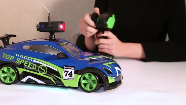 Woman operating radio-controlled model of sports car. — Stock Video