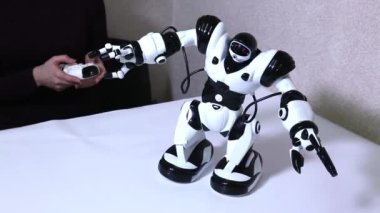 Kadın masada radyo kontrollü beyaz robot kontrolleri.
