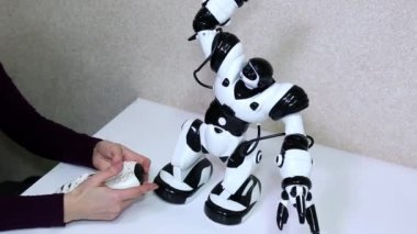 Kadın bir tabloda radyo kontrollü beyaz robot kontrolleri.