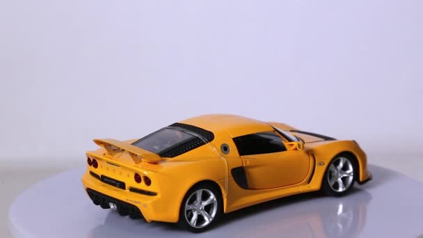 Gele Lotus sportwagen schaal Modelauto draaien tegen een witte achtergrond. — Stockvideo