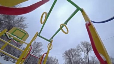 Çocuk salıncaklar Şehir Parkı bir oyun alanı üzerinde güneşli kış gününde boş, altından görüntülemek, aydınlatma.