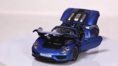 Berlin, Almanya - Ocak. 2019: mavi Porsche 918 Spyder ölçek model spor araba ile açılan kapılar ve başlık üzerinde izole beyaz arka plan döndürme.