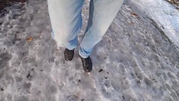 Man dressed in blue jeans walks in the snow on a winter day. — Stock Video