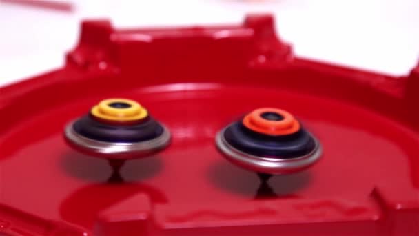 流行的现代儿童游戏贝叶刀爆裂快速旋转在红色的竞技场上 陀螺仪 纺纱机日本玩具 — 图库视频影像