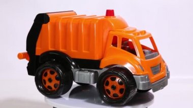 Turuncu oyuncak garaj kamyon ölçekli model araba beyaz arka planı döndürme.