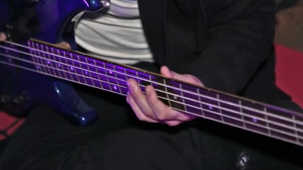 Man Bass gitarist spelen op elektrische basgitaar op concert. Toets close-up. — Stockvideo