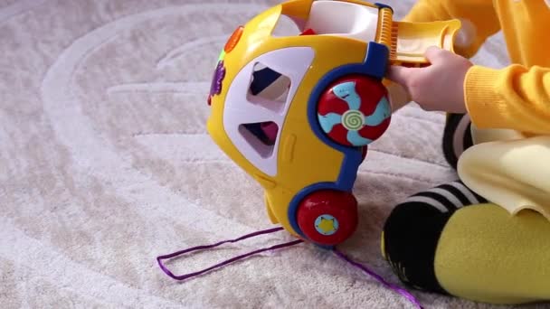 Little Girl Plays Yellow Educational Toy Car Sitting Floor Kindergarten — Stock Video