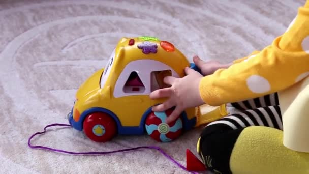 Маленька Дівчинка Грає Жовтим Навчальним Іграшковим Автомобілем Сидячи Підлозі Дитячому — стокове відео
