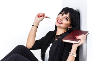 Bir defter tutan genç güzel mutlu esmer kadın giyinmiş 