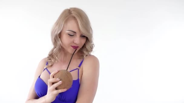 코코넛에서 주스를 마시는 파란색 비치웨어를 매력적인 여자의 초상화 그녀의 얼굴에 — 비디오