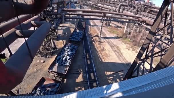 貨物列車は、冶金プラントの領土にワゴン内の金属スクラップの inglots を輸送します。上から見た. — ストック動画