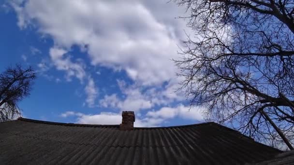 Time lapse of old brick chimney on a tiled roof against a cloudy sky at sunny day. — Stock Video