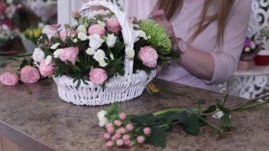 Kadın çiçekçi beyaz sepet güller güzel çiçek buket yapma. Floral iş konsepti.
