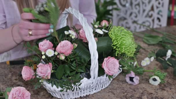 白いバスケットでバラの美しい花の花束を作る女性の花屋 フラワービジネスコンセプト — ストック動画