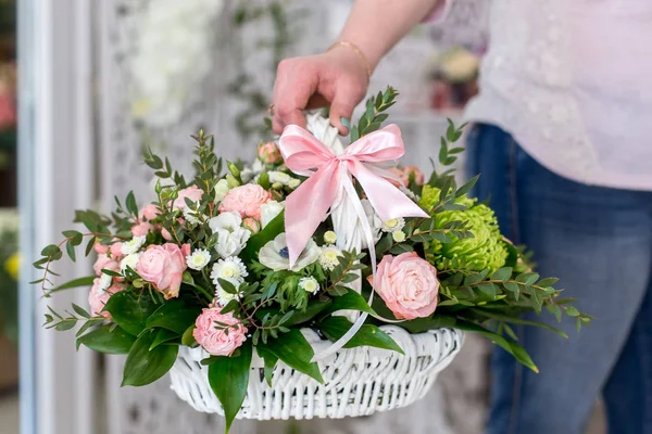 Kvinna florist innehar en vacker bukett rosor i vita bas — Stockfoto