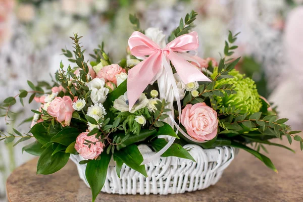 Belo buquê de rosas em cesta branca está em uma mesa em fluxo — Fotografia de Stock