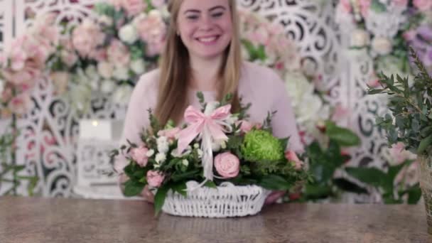微笑的年轻花商女子给一个美丽的玫瑰花束的相机 专注于花束 花卉经营理念 — 图库视频影像