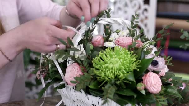 女花匠在白色篮子里美丽的玫瑰花束上做彩带弓 — 图库视频影像