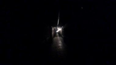 İşçi, metalurji fabrikasının karanlık bir koridorunda yürüyor. Pov, kamera görüntüsü.