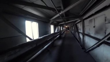 İşçi, metalurji fabrikasının karanlık bir koridorunda yürüyor. Pov, kamera görüntüsü.
