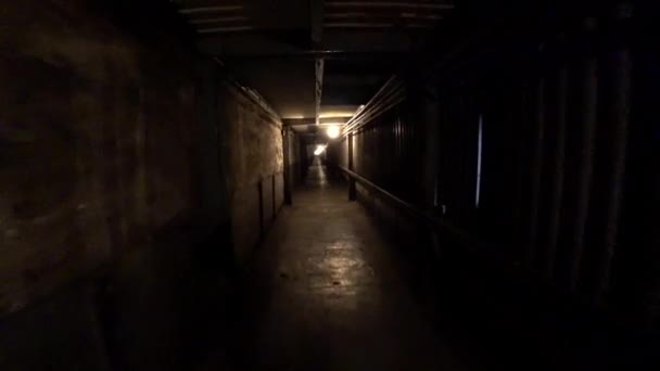 Worker walk through a dark corridor at a metallurgical plant. POV, action camera shot. — Stock Video