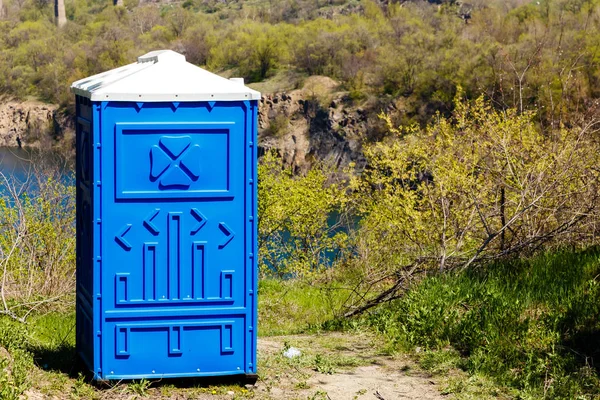 Blauwe cabine van bio toilet in berg Park op zonnige zomerdag. — Stockfoto